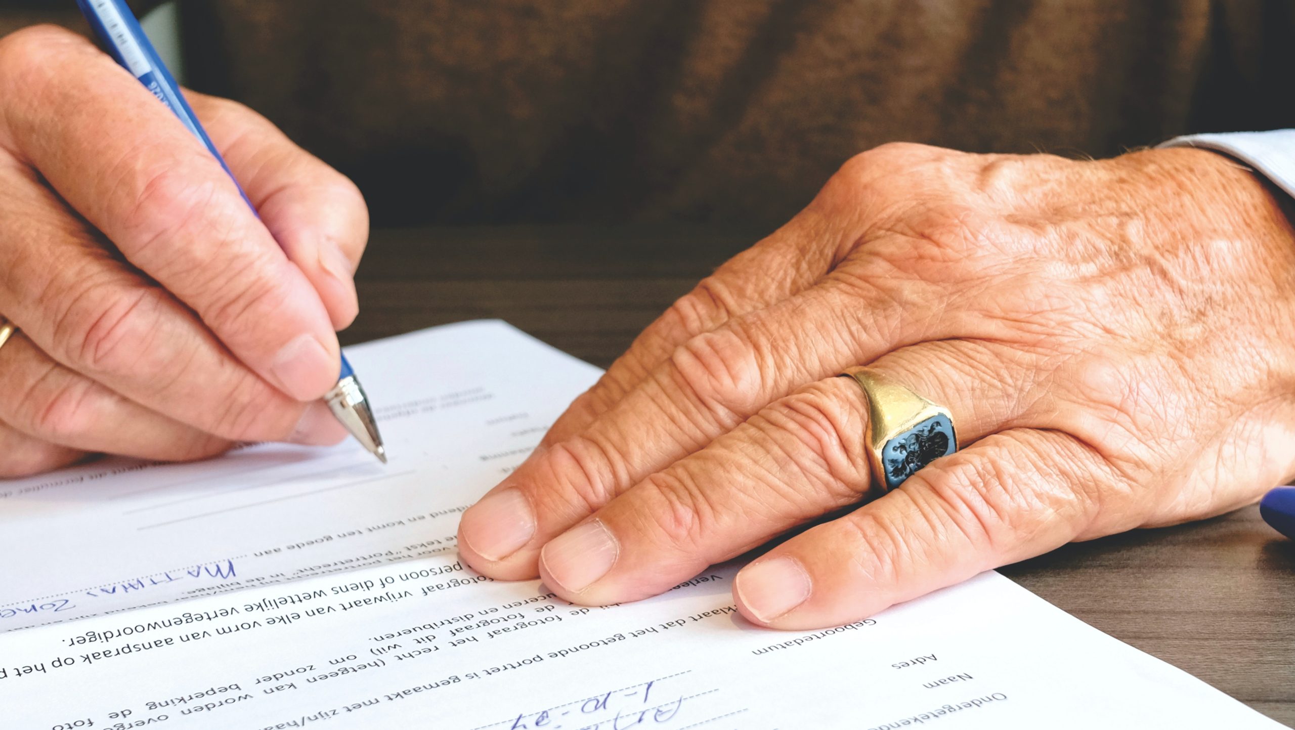 man signing document with pen